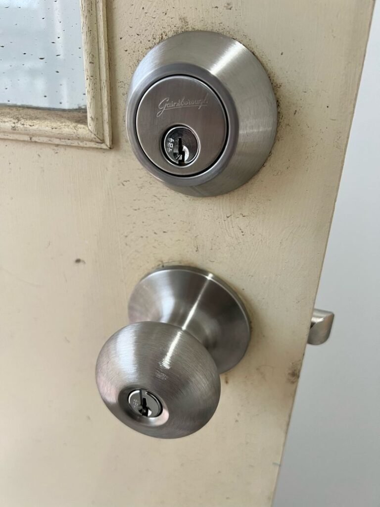 Close-up of a door with newly installed deadbolt and doorknob locks.