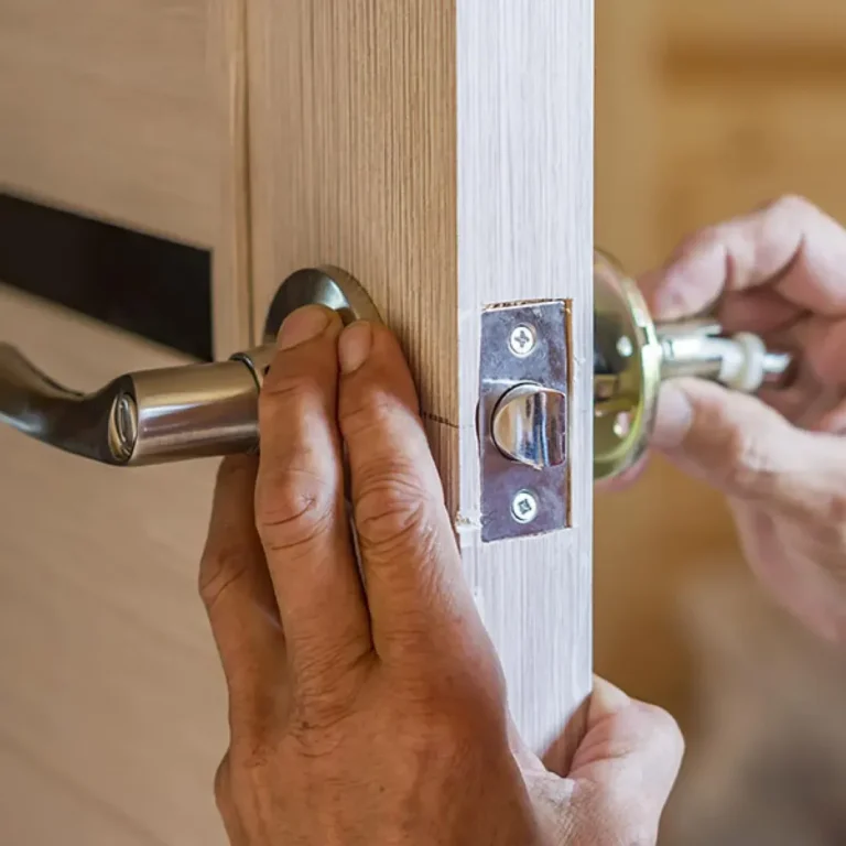 Hands installing a door lock on a wooden door